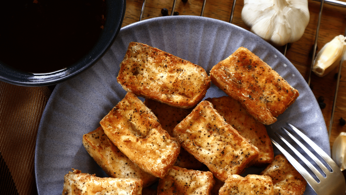 hot and fresh, fried crispy tofu on a wooden table