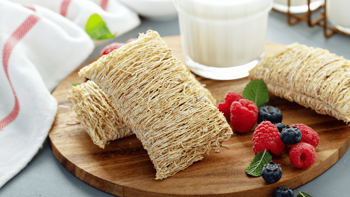 shredded wheat beside a glass of plant-based milk